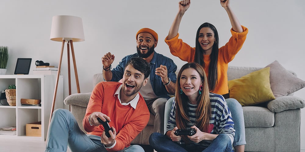 group male and female teens playing a video game on a couch