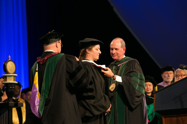 Dean Terence Flotte and Chancellor Michael F. Collins award an honorary degree to Monica Coenraads.