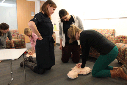 Cardiologist and learning community mentor Cynthia Ennis, DO, observes as medical students practice hands-only CPR at a Blackstone House training event.