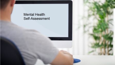 man in front of computer screen looking at mental health self assessment