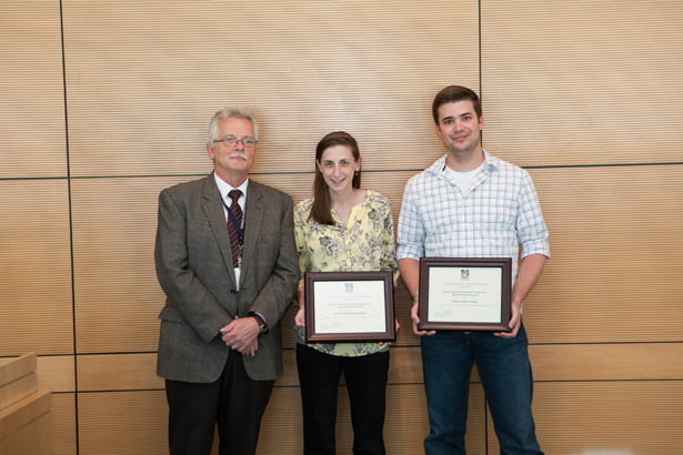 Dean Anthony Carruthers presents awards for the Most Insightful Mid-thesis Research to Sara Lewandowski and David Mofford.