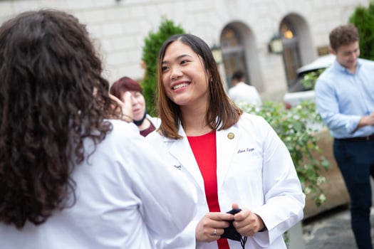 Second-year medical student Alexandra Nguyen shares a laugh after the White Coat Ceremony for the Class of 2024.