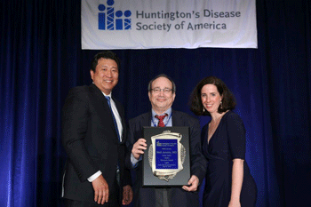 Neil Aronin receives the HDSA Research Award from HDSA CEO Louise Vetter (right) and HDSA board chair Jang-Ho Cha, MD, PhD.