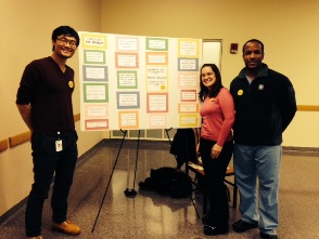 Fourth-year medical students (l to r) Shu Yang, Melinda Palma and Waldo Zamor with the GHHS Tell Me More poster on National Solidarity Day for Compassionate Care.