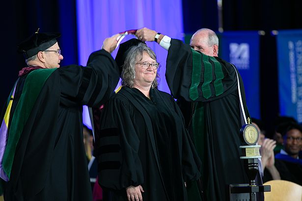 Susan Mailman is hooded by Dean Terence R. Flotte and Chancellor Collins after receiving her honorary degree.