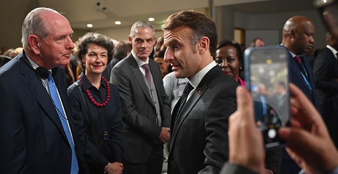 Chancellor Michael F. Collins standing next to French President Emmanuel Macron