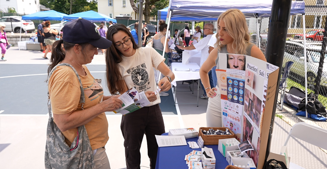 Jessica Orofino (center) and Carolyn Foley (right) provided information about melanoma at Grant Square Park in August.