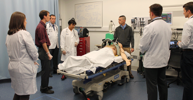 Kavita Babu, MD, (fourth from left) leads a demonstration of a simulated overdose response in an emergency room. The demonstration is part of new opioid conscious curriculum. 