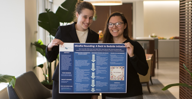 Emily Levoy, MD, (left) and Emily Chen, MD, with a poster detailing their grant 