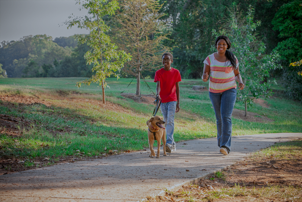 Parent and child walking with a dog